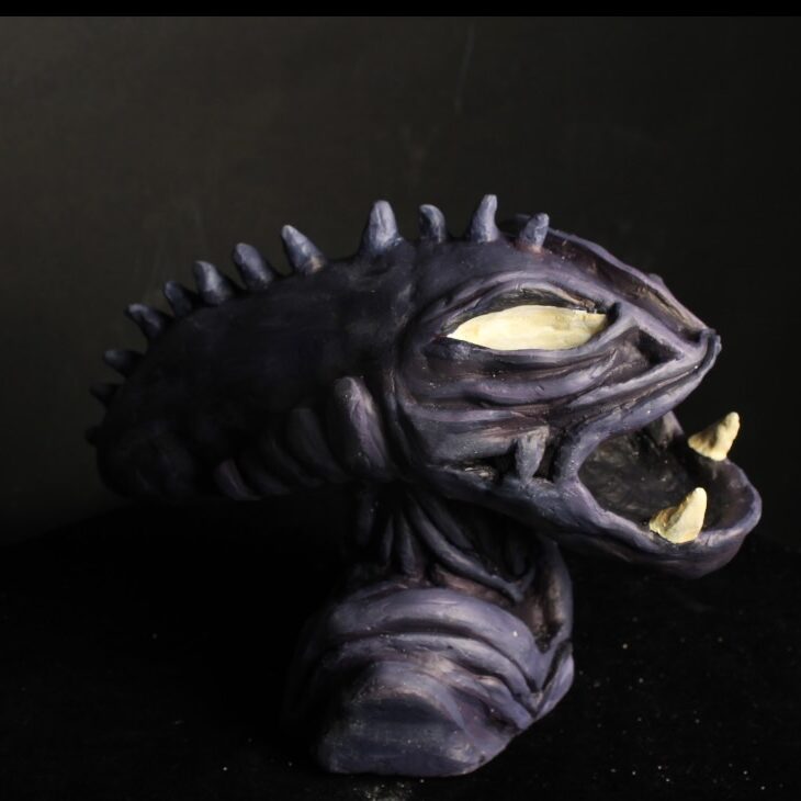 Clay sculpture of an Alien head looking to the right